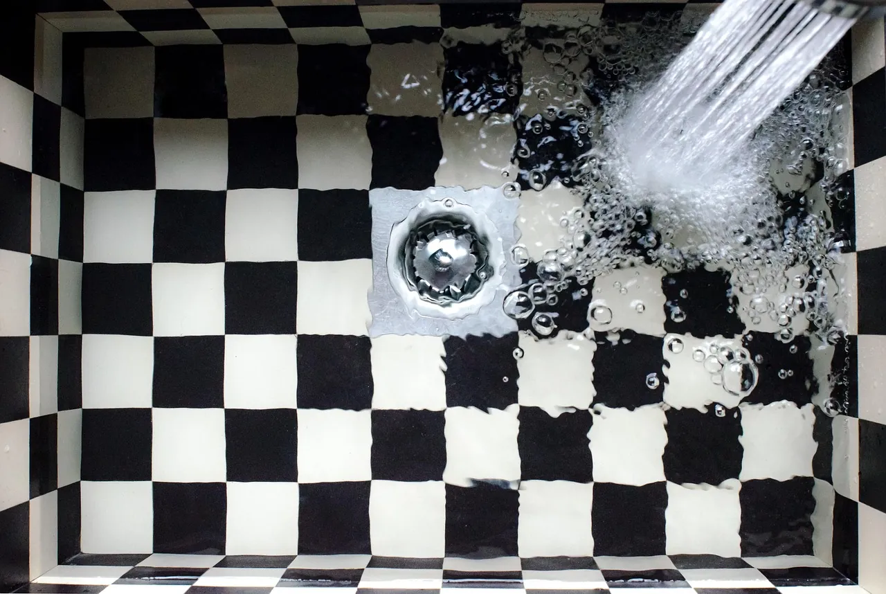 Water draining from a faucet into a kitchen sink drain